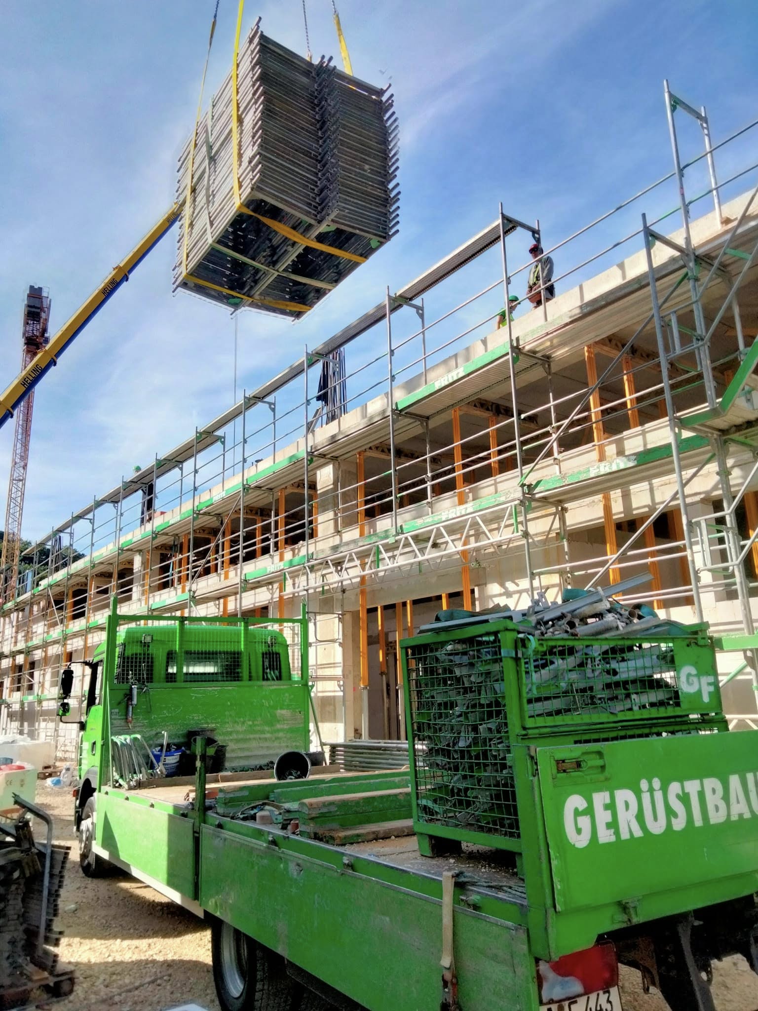 Kran hebt Gerüstmaterial auf die Baustelle