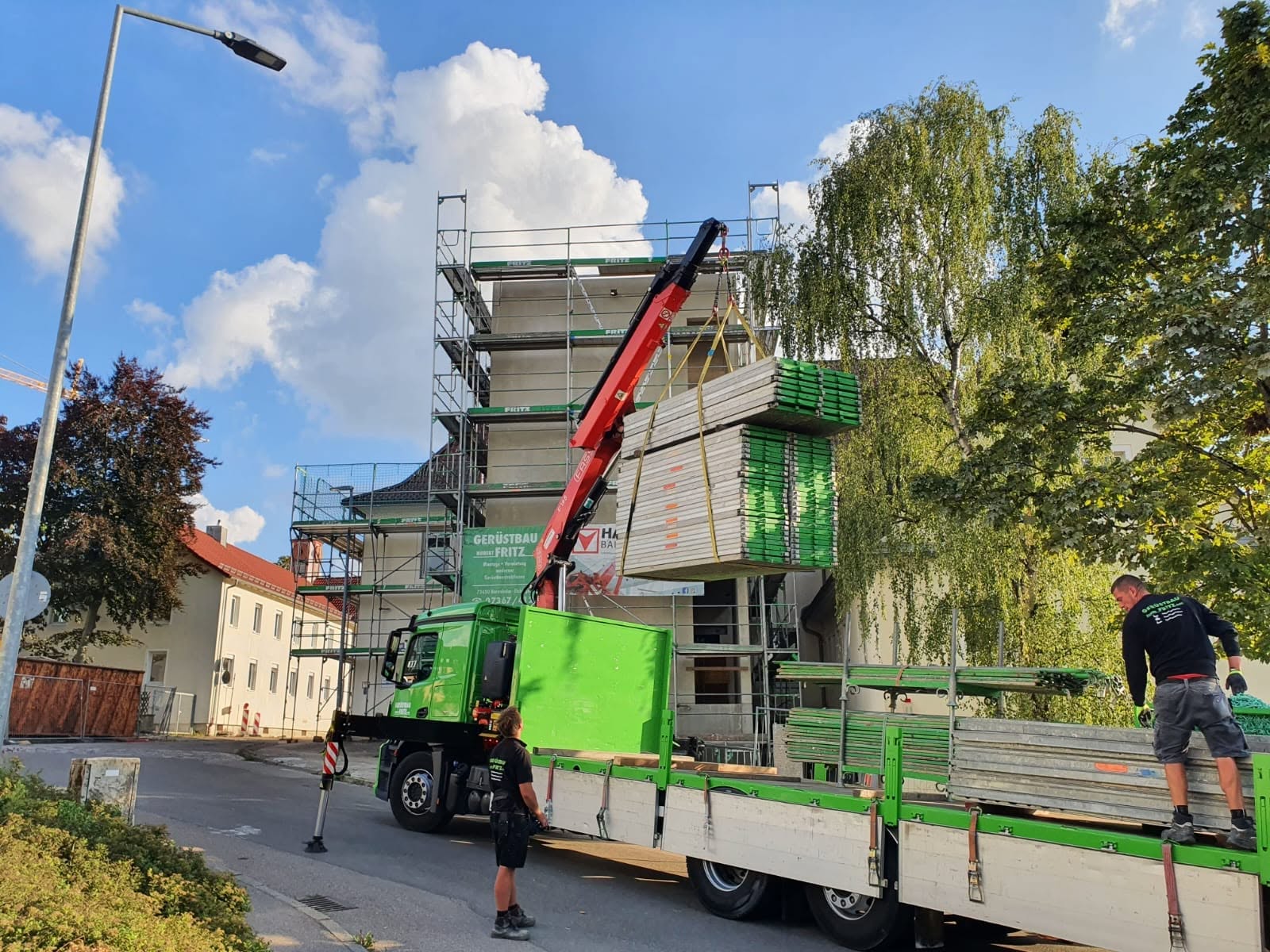 LKW mit Ladekran beim Gerüst-Antransport